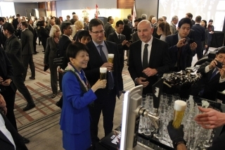 写真:企業展示ブースでのグヤーシュ首相府 長官と佐藤大使のアサヒビール試飲